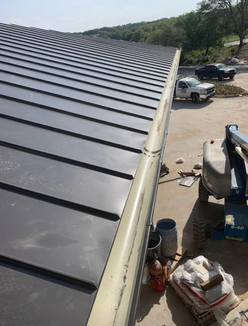 Standing seam panel and gutter detail on a metal roofing jobsite in Mooresville